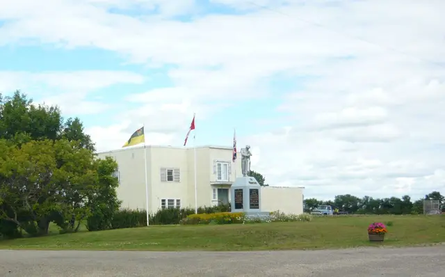 War memorial and flags beside the community building